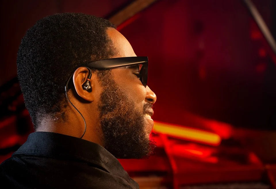 Beyerdynamic DT 73 IE in-ear studio headphones worn by musician Cory Henry, showcasing detailed earbud design and branding.